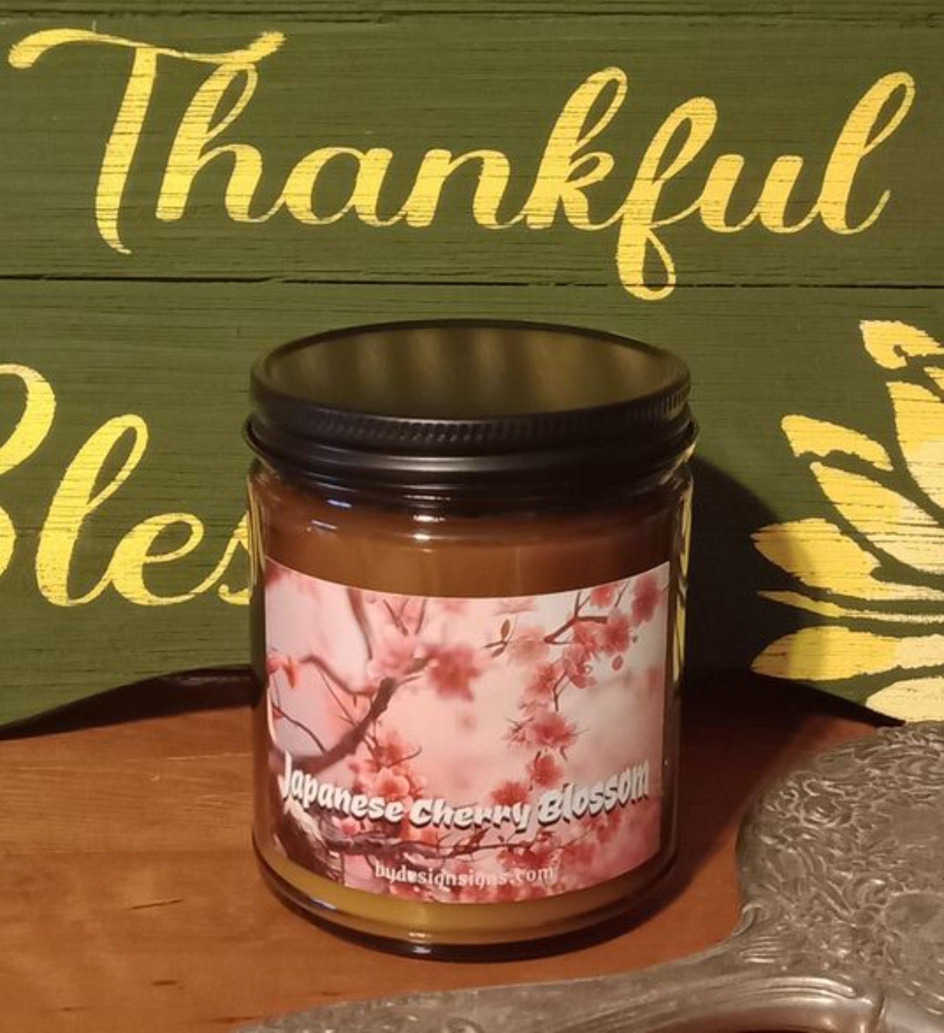 Image of a 9oz Dark Glass Jar Wood Wick Scented Candle with the image of Cherry Blossoms and the words Japanese Cherry Blossom written on it.